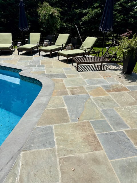 Full color natural cleft flagstone pool deck with custom thermal bluestone pool coping.