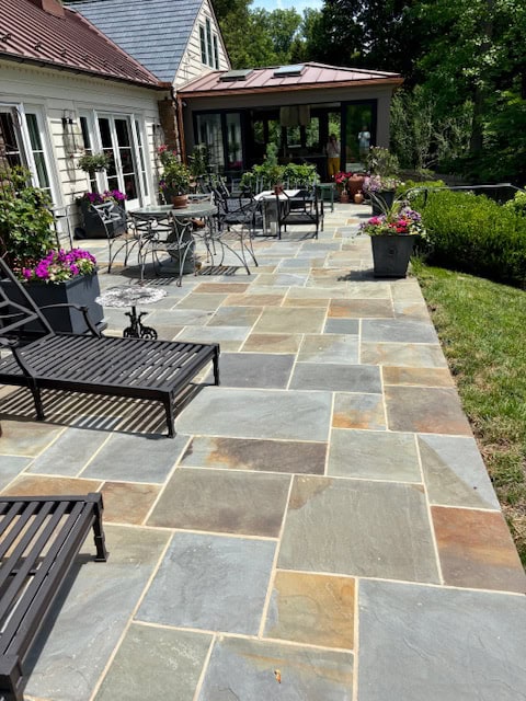 Full Color Flagstone Full color natural cleft Pennsylvania bluestone patio in a random rectangular pattern layout behind a residential home.
