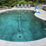 Custom Bluestone Pool Coping Inground freeform swimming pool with bullnosed bluestone coping and patio seating.