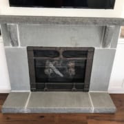 Custom bluestone fireplace surround with rock-faced mantel shelf and raised hearth.