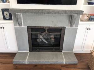 Custom bluestone fireplace surround with rock-faced mantel shelf and raised hearth.